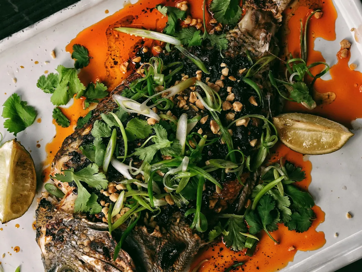 Weißer Teller mit Fisch und Gemüse
