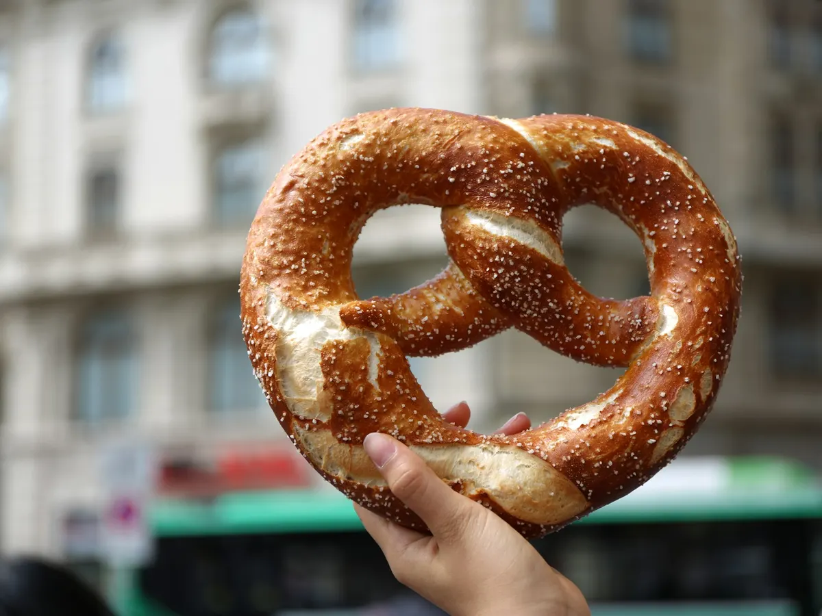 Hand hält eine frisch gebackene Breze