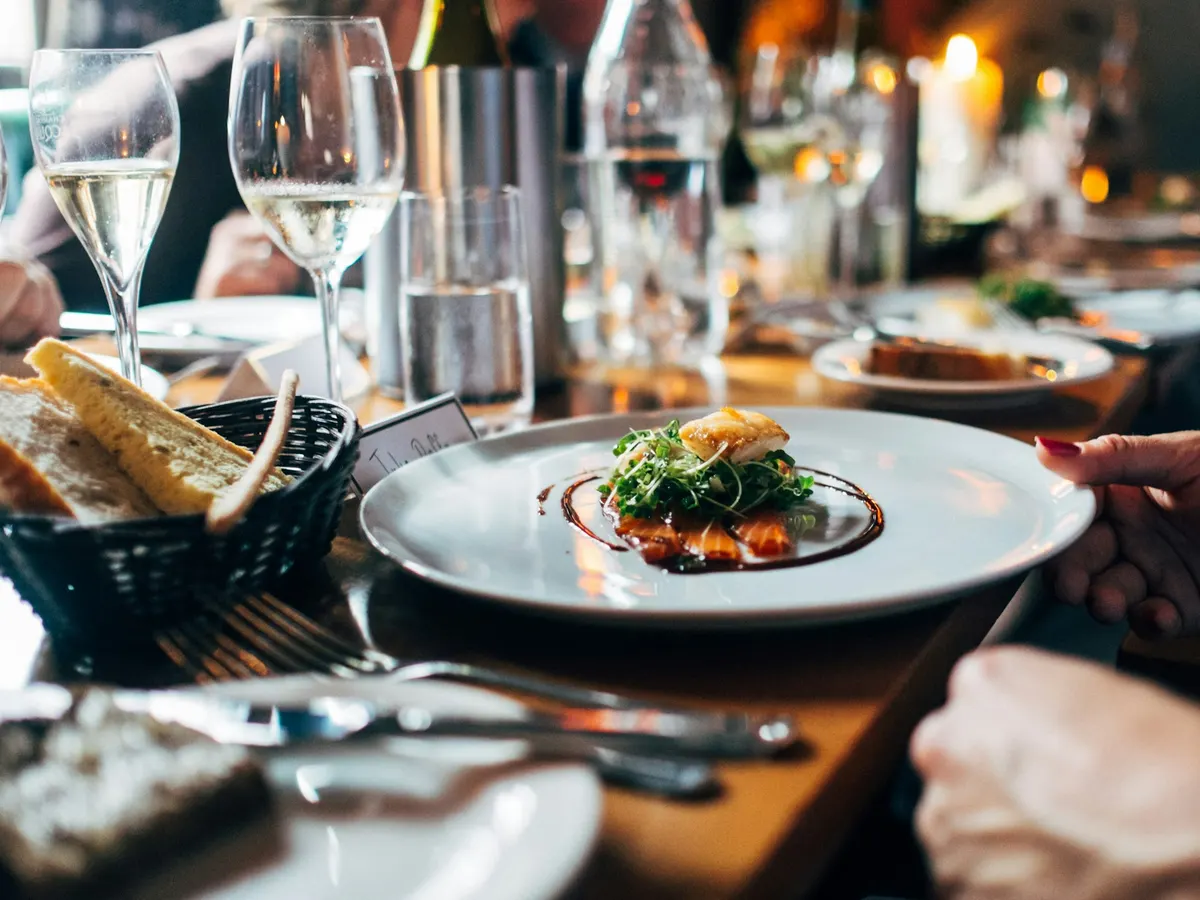 Elegant angerichteter Fisch mit Weißwein am Tisch