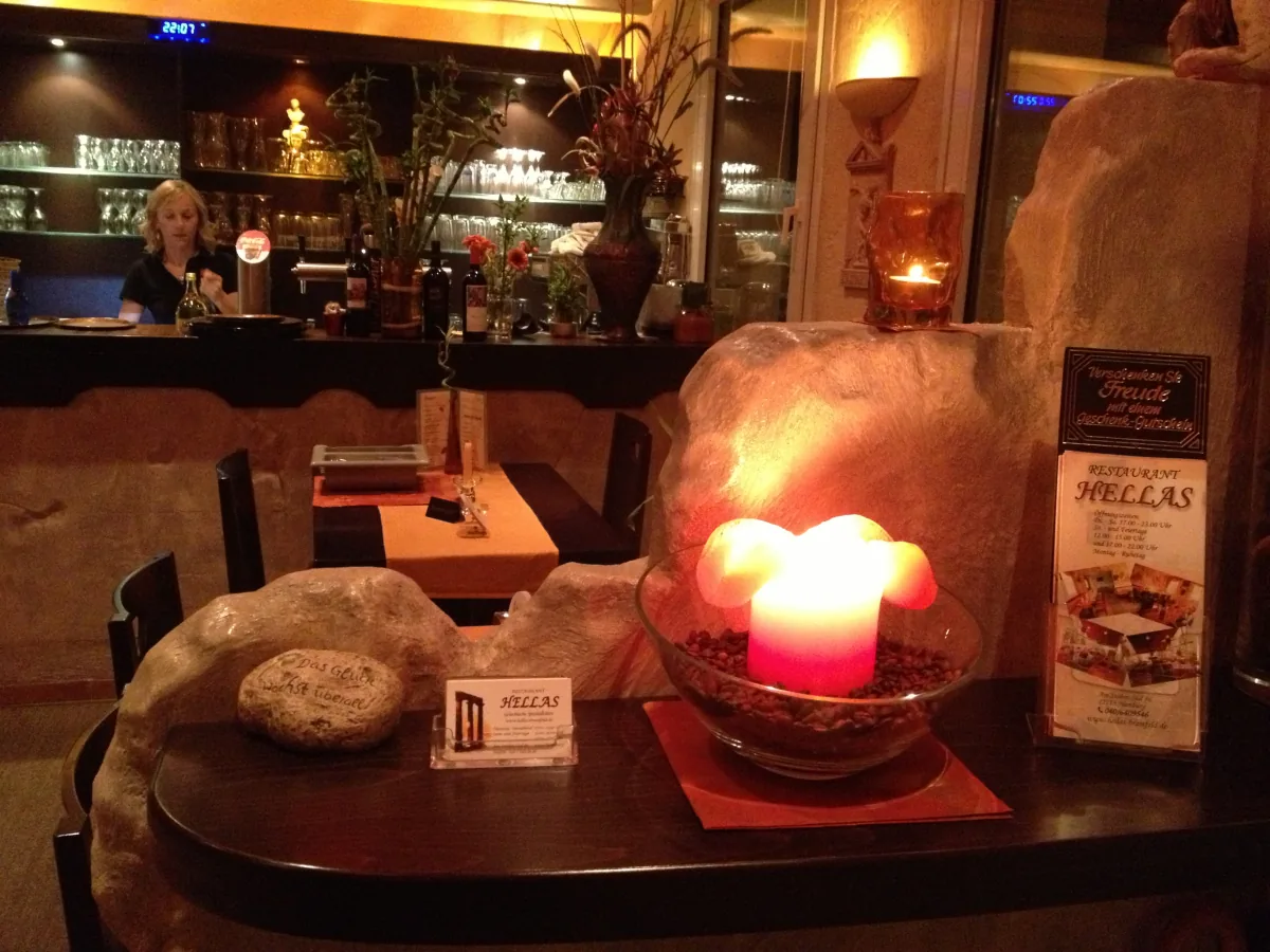 Tisch mit brennenden Kerzen vor der Bar des Restaurants