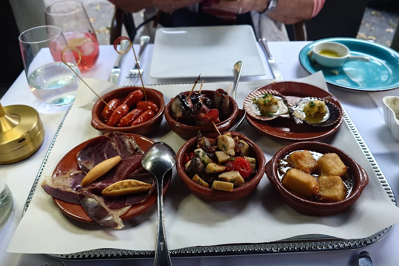 Tontöpfchen mit Tapas auf gedecktem Tisch