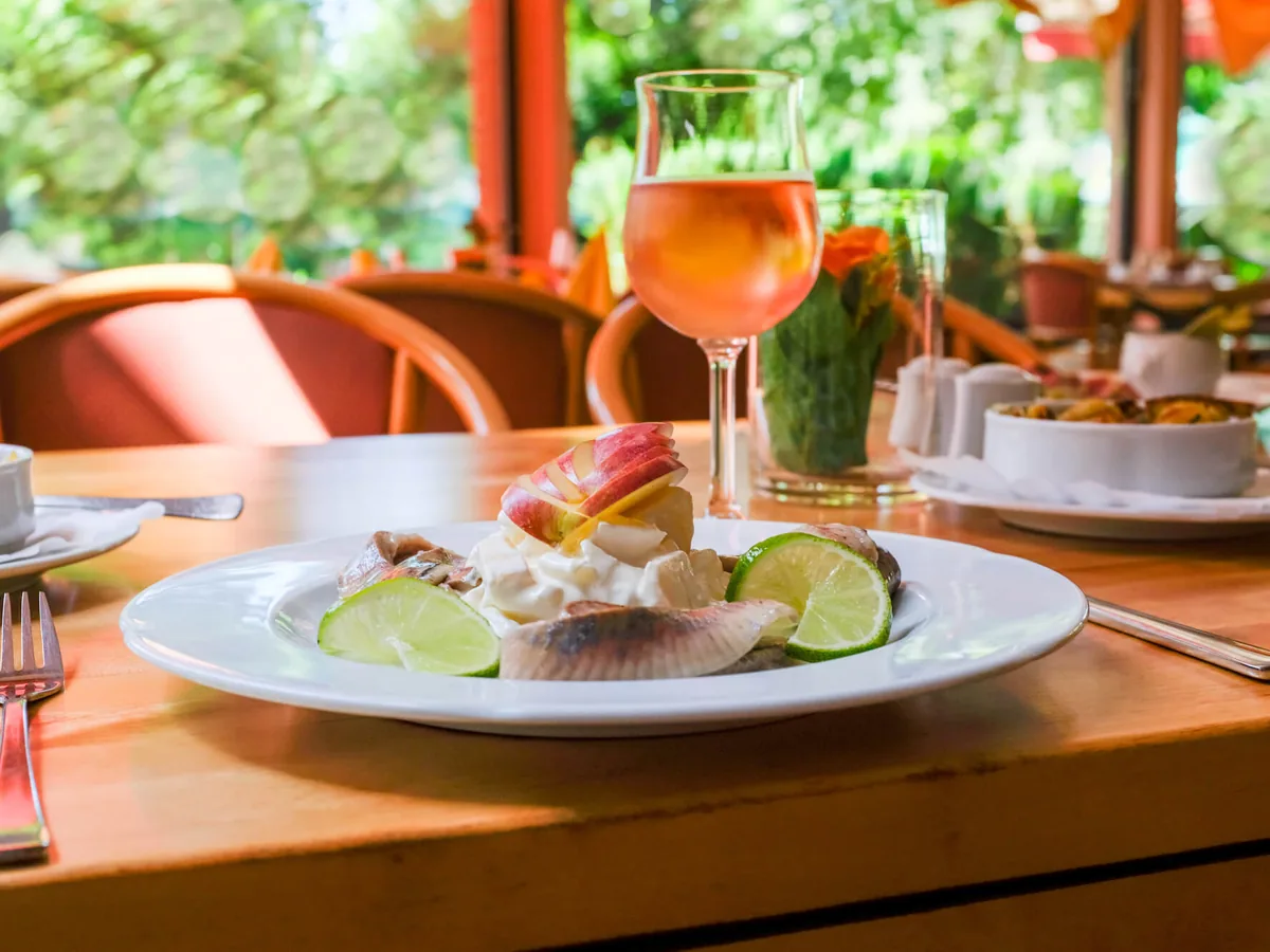 Fischteller mit Limette auf einem Holztisch der Terrasse