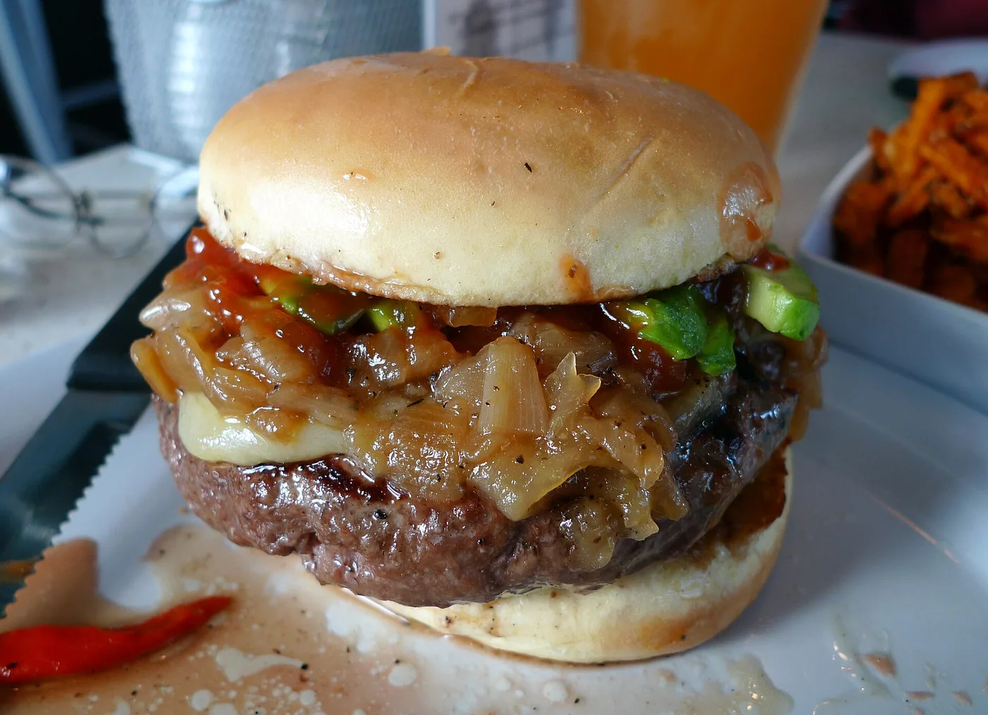 Burger mit Röstzwiebeln, Käse und Jalapeños in Nahaufnahme