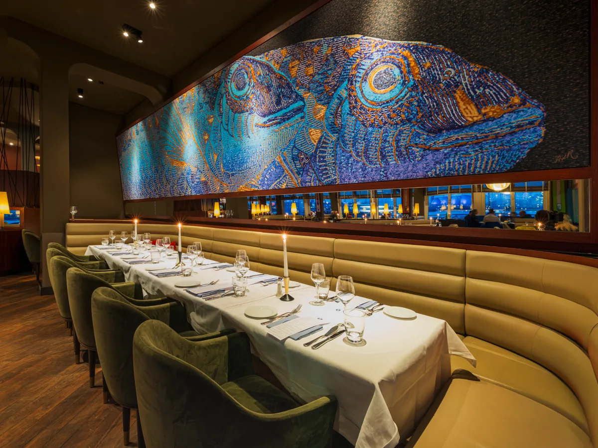 Gastraum des Rive mit großem Fischmosaik an der Wand