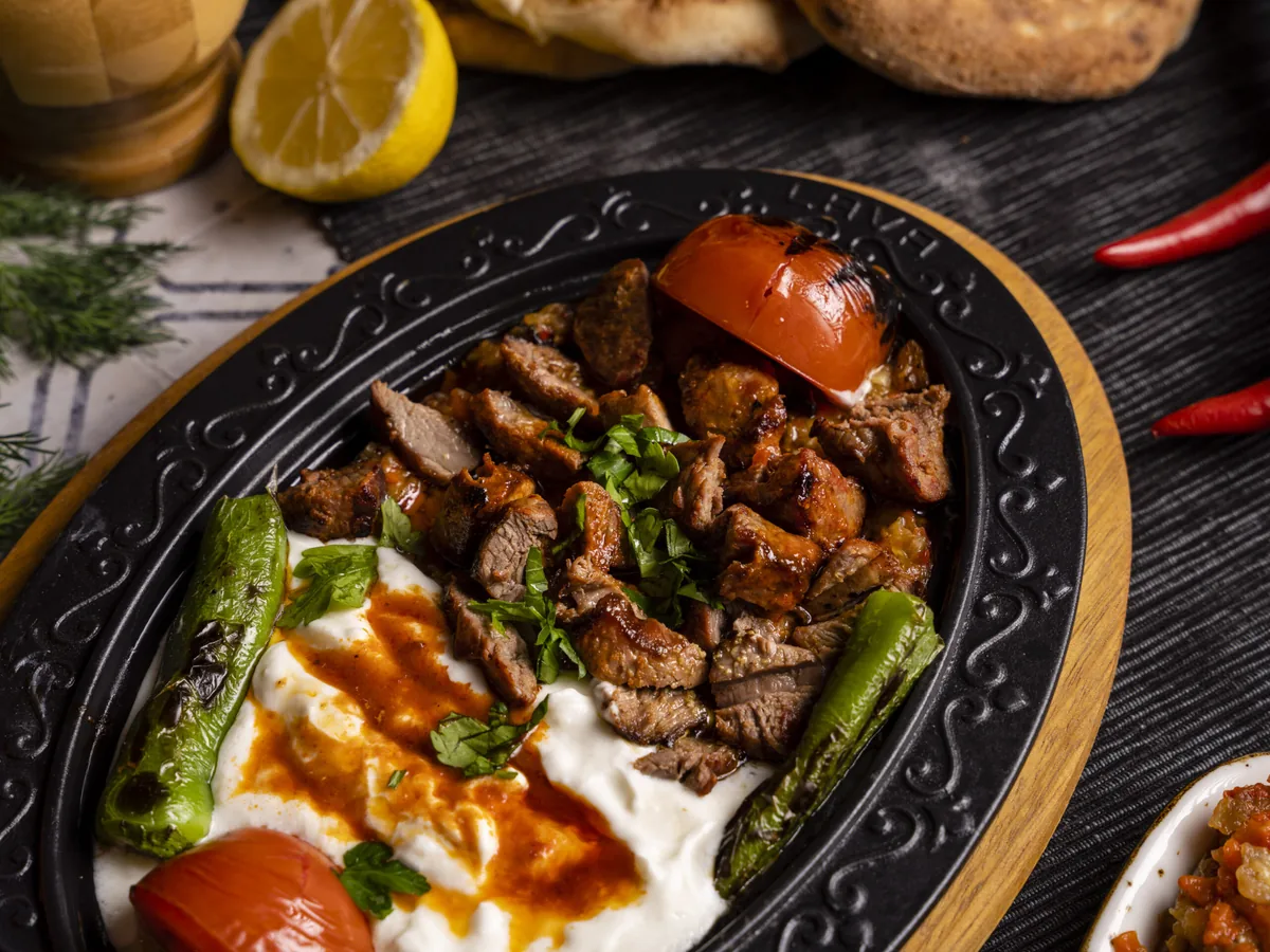 Teller mit gegrilltem Fleisch, Joghurt und Tomate vom Holzkohlegrill