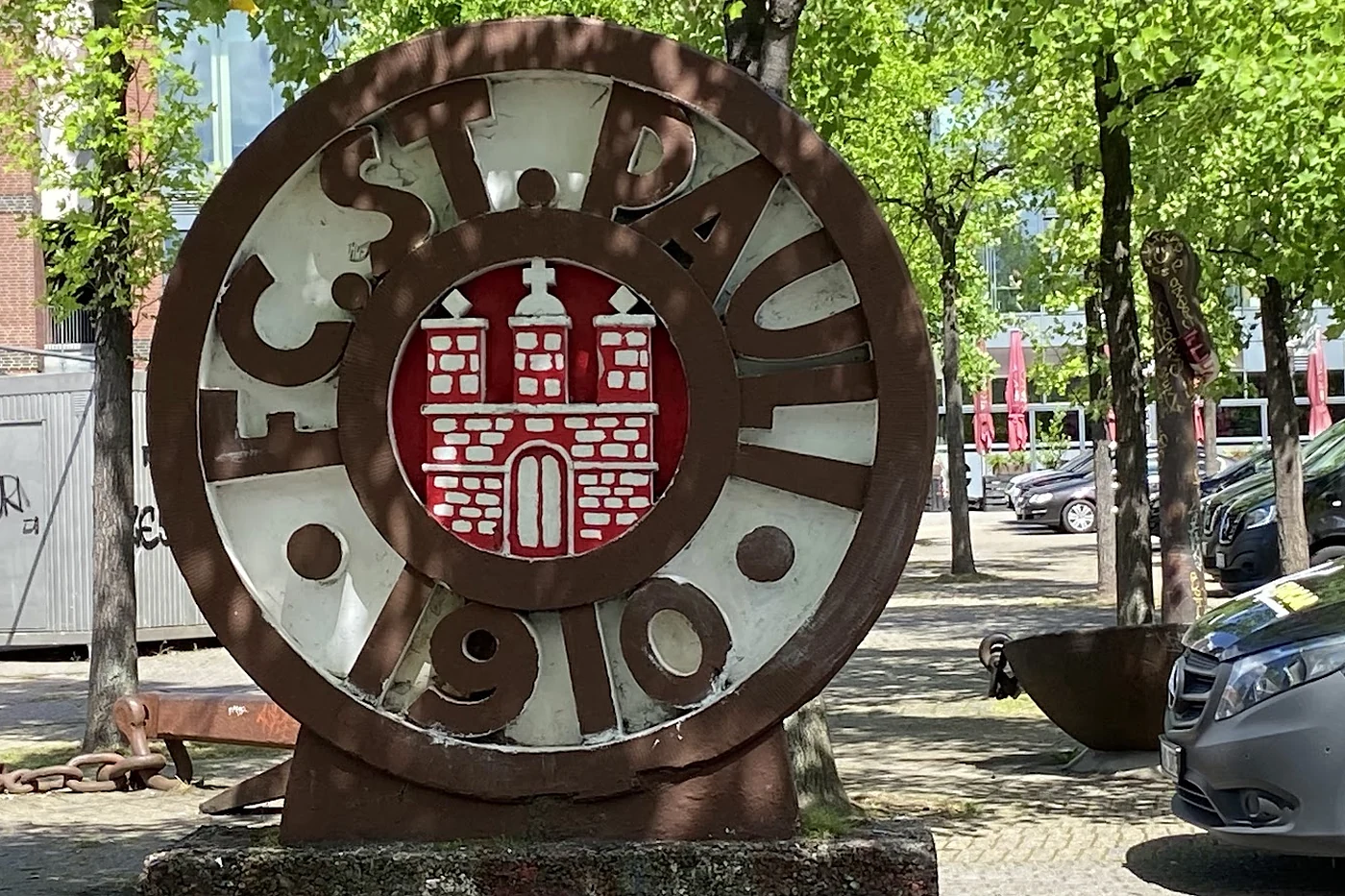 Skulptur mit dem Vereinswappen an einer Straße