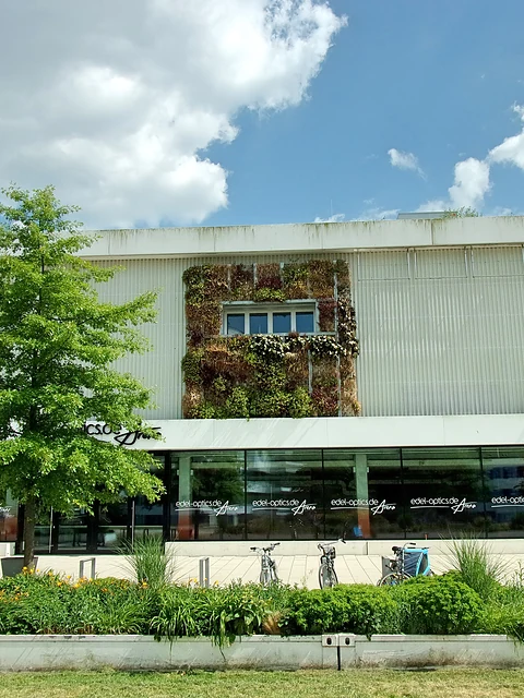 Fassade der Sport- und Veranstaltungshalle im Inselpark mit begrünten Elementen