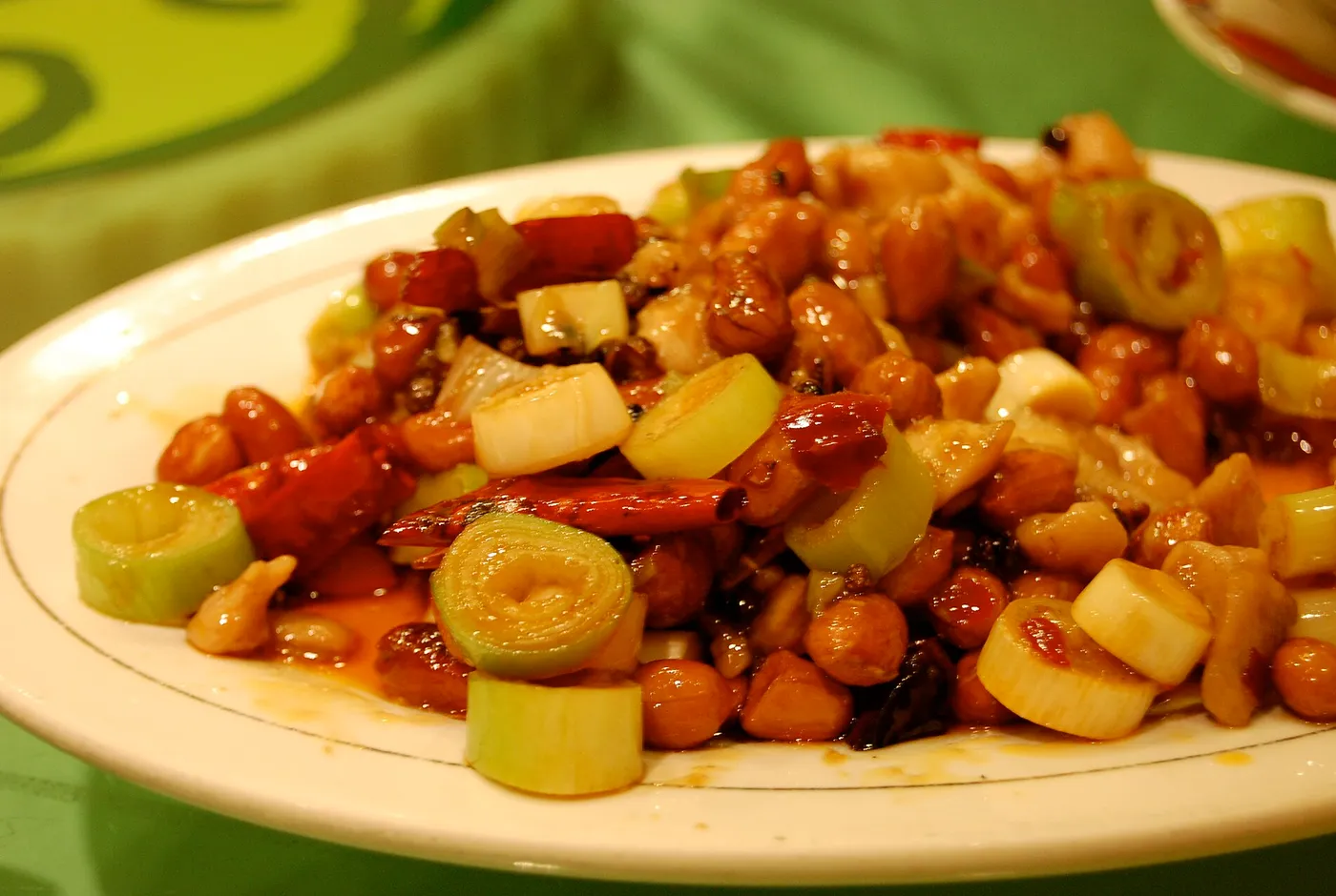 Wokgericht mit Fleischwürfeln, Cashewkernen, Lauch und getrockneten Chilis