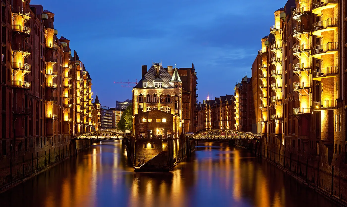 Speicherstadt Hamburg bei Nacht mit beleuchtetem Wasserschloss und Fleet