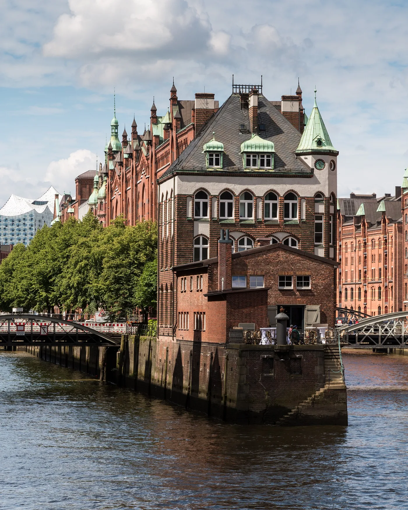 Wasserschloss in der Speicherstadt bei Tag mit Backsteinspeichern und Elbphilharmonie im Hintergrund