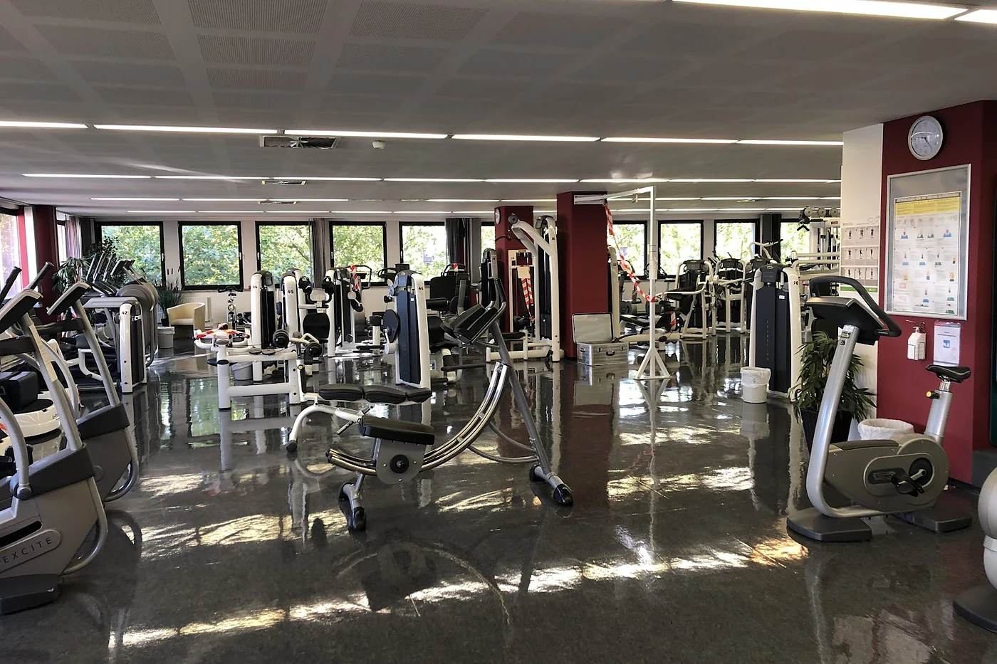 Große Trainingsfläche mit Geräten unter einer Holzdecke