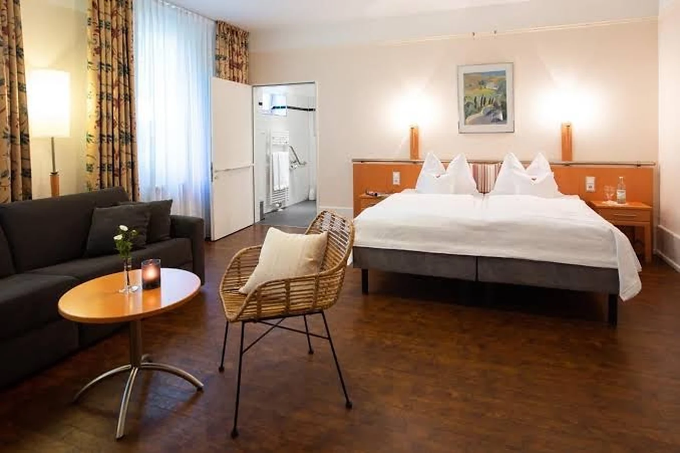 Zimmer mit Doppelbett, Sofa und rundem Tisch