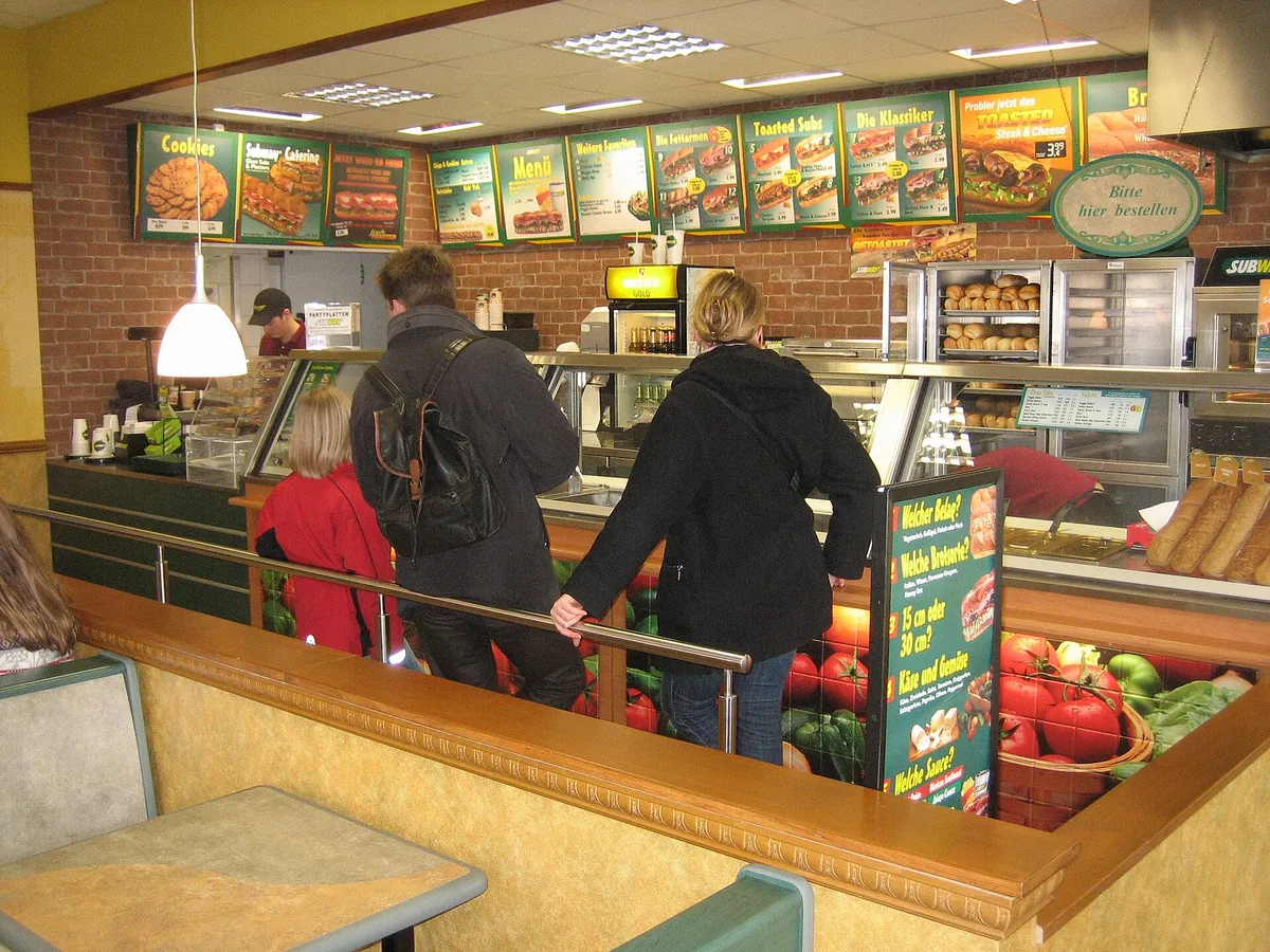 Tresen einer Subway-Filiale mit Zutatenauslage und Menütafeln