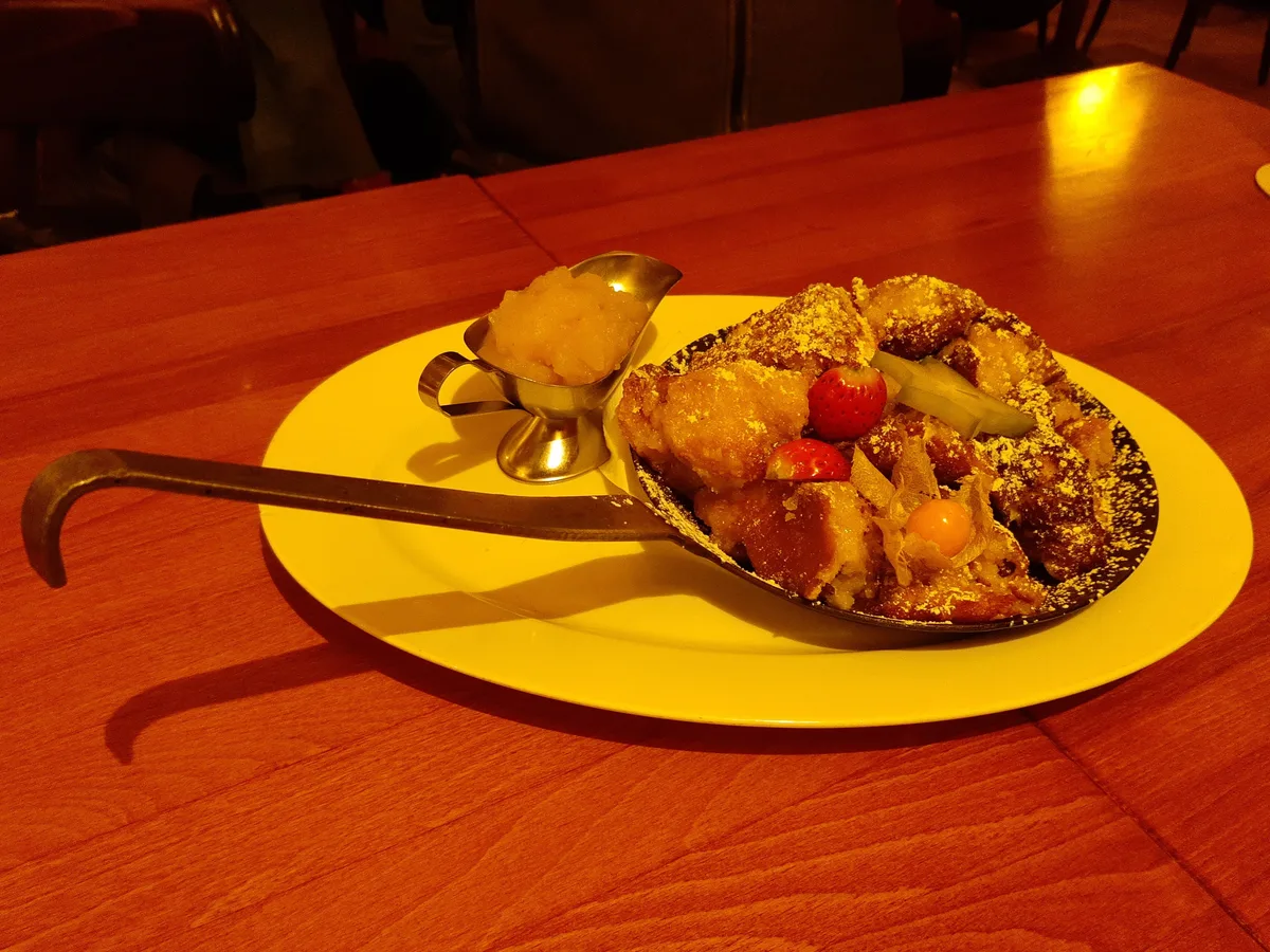 Kaiserschmarrn mit Puderzucker und Apfelmus auf einem weißen Teller