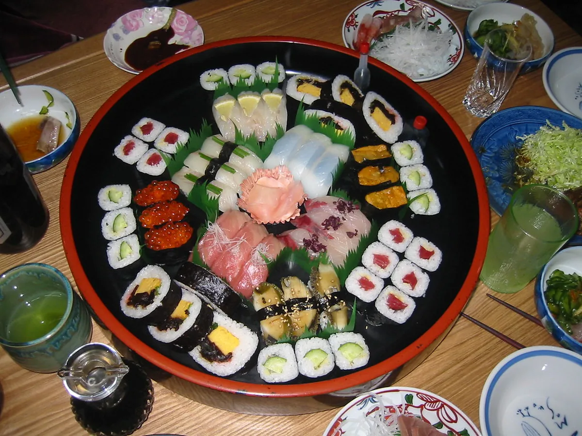 Große Sushi-Platte mit Maki, Nigiri und Beilagen auf dem Tisch