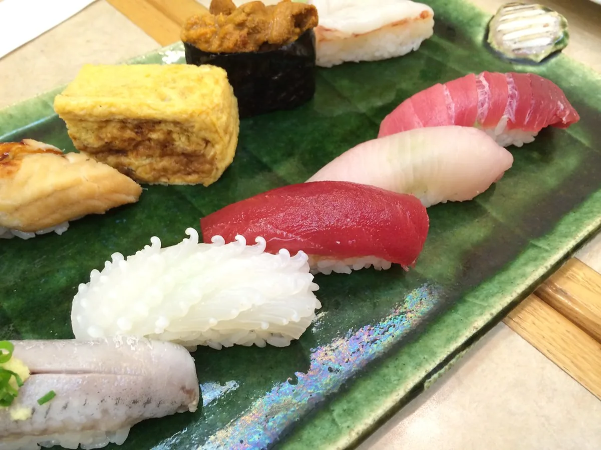 Nigiri mit Lachs, Thunfisch und Omelett auf grünem Blatt