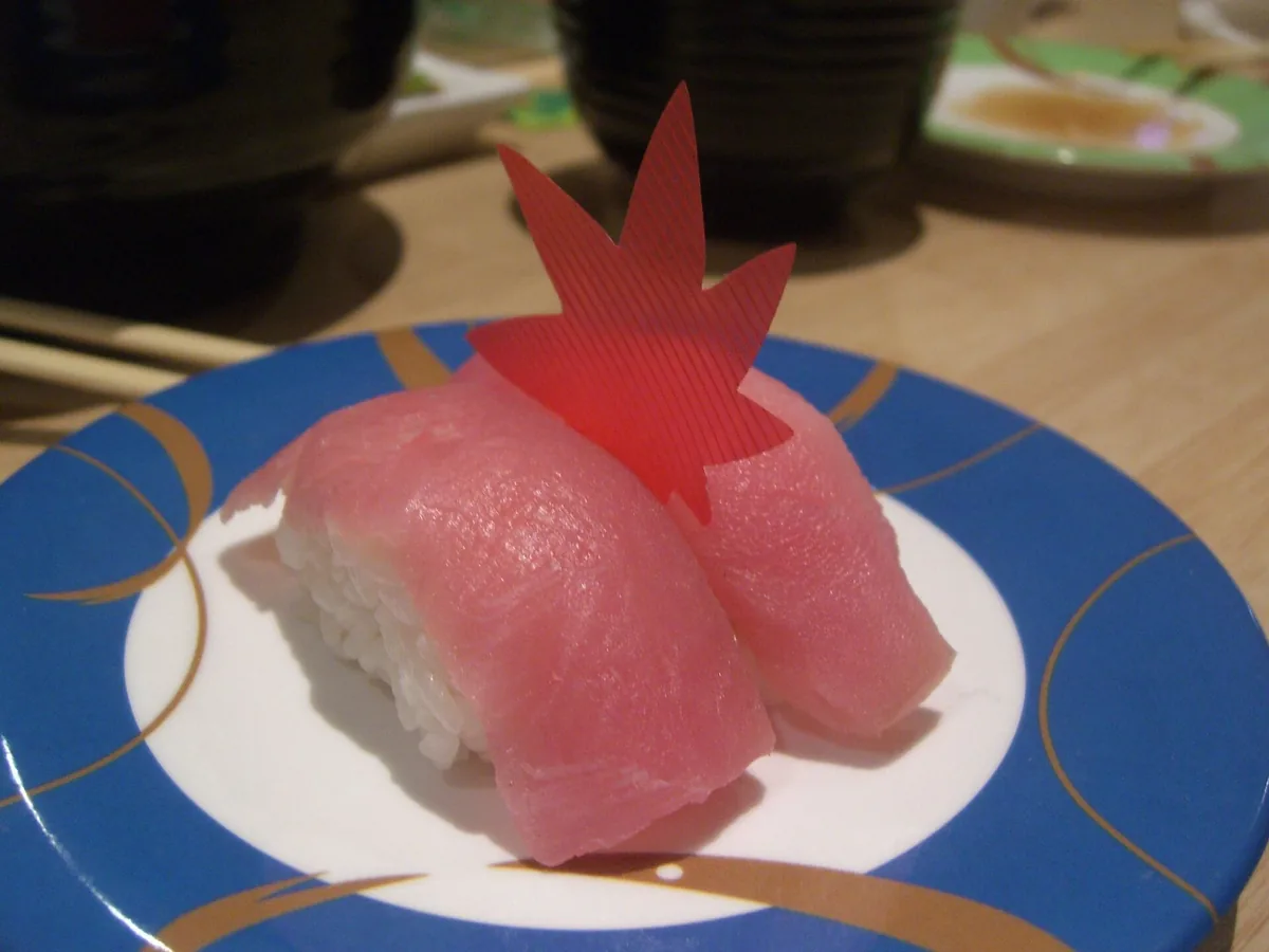 Zwei Nigiri mit Thunfisch auf einem blau gemusterten Teller