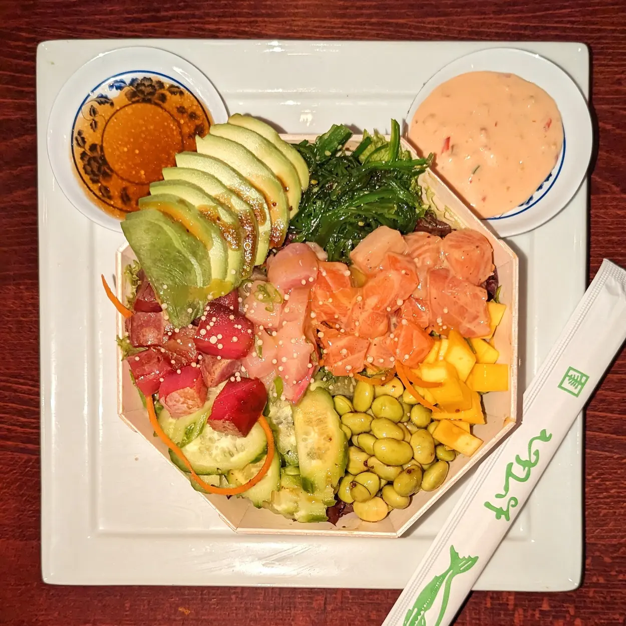 Poke Bowl mit Lachs, Thunfisch, Avocado, Mango, Edamame und Algensalat