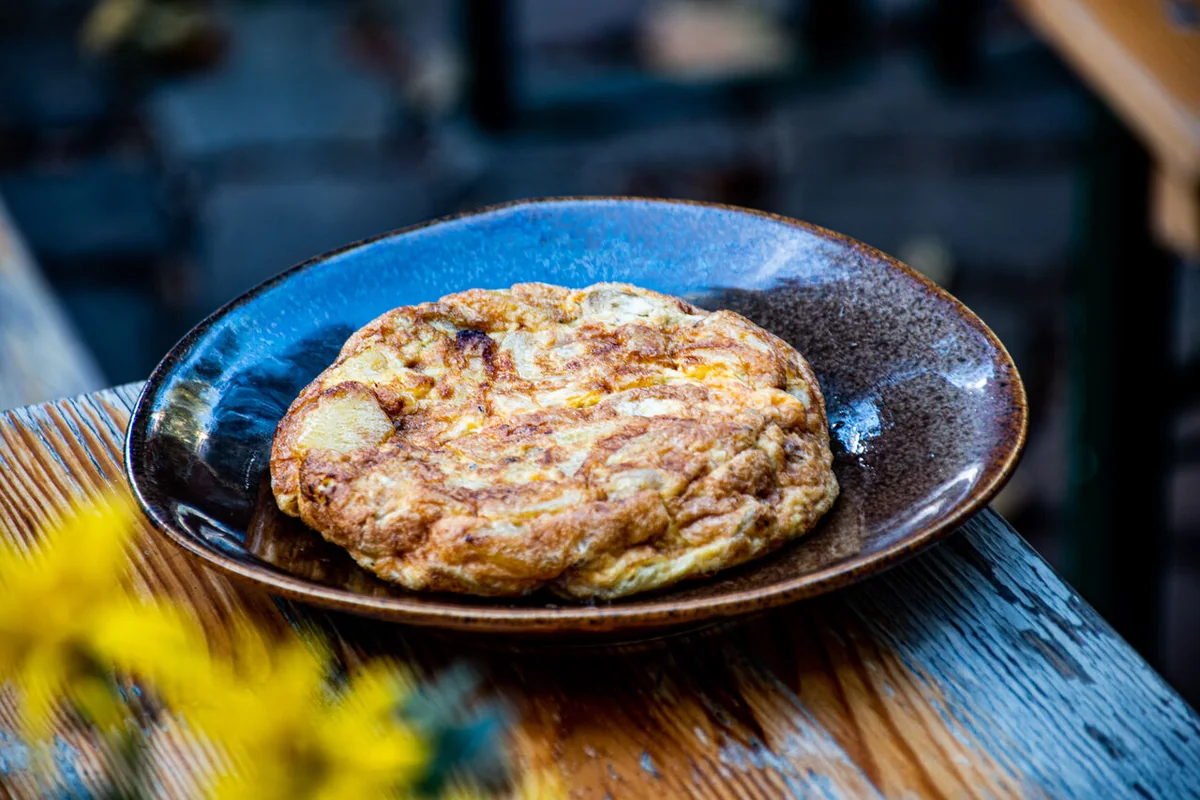 Spanische Kartoffeltortilla auf einem blau glasierten Teller