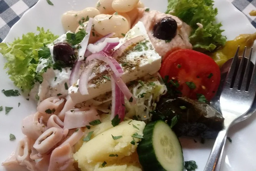 Kalamaris-Salat mit Feta, Tomate, Gurke, Weinblatt und weißen Bohnen auf Salat