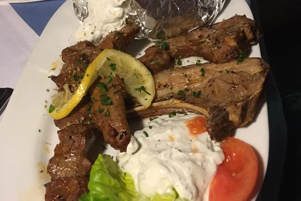Lammkoteletts und Souvlaki mit Zitrone, Tzatziki, Salat und Tomate