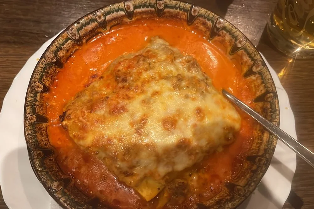 Lasagne mit Käse überbacken in Tomatensauce in einer Tonschale