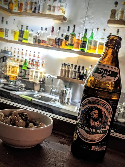 Flasche Augustiner Helles und eine Schale Erdnüsse auf dem Tresen der Toast Bar