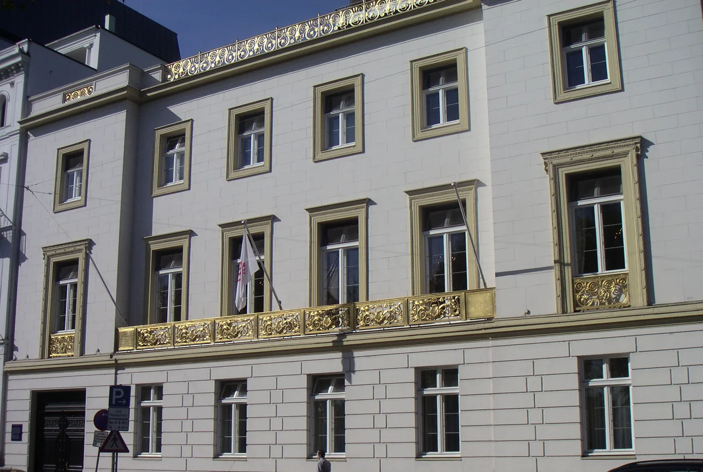 Fassade des Amsinck-Hauses mit vergoldeter Balustrade und Clubflagge