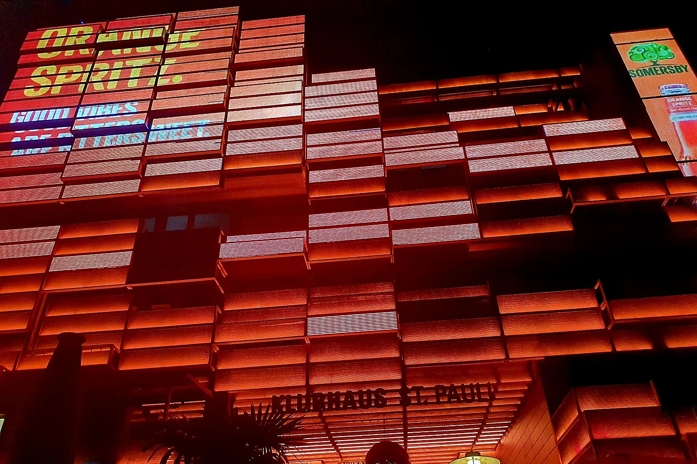 Medienfassade des Klubhauses St. Pauli bei Nacht in Orange mit dem Schriftzug Klubhaus St. Pauli