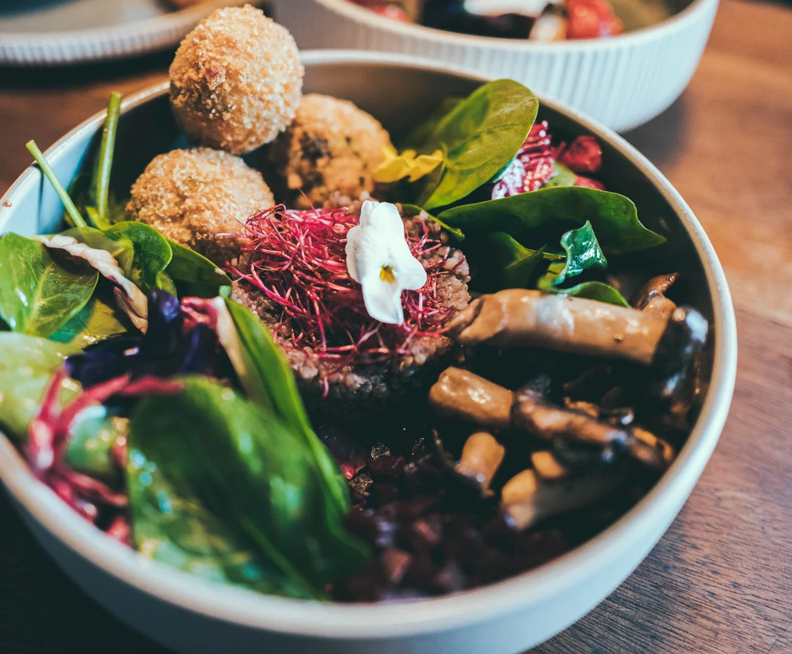 Schale mit Spinatsalat, panierten Kroketten, Pilzen und roter Bete