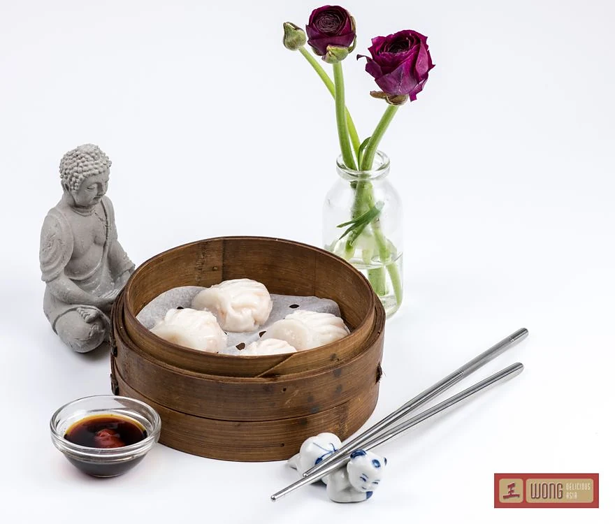 Dim Sum im Bambuskörbchen mit Sojasauce und Stäbchen