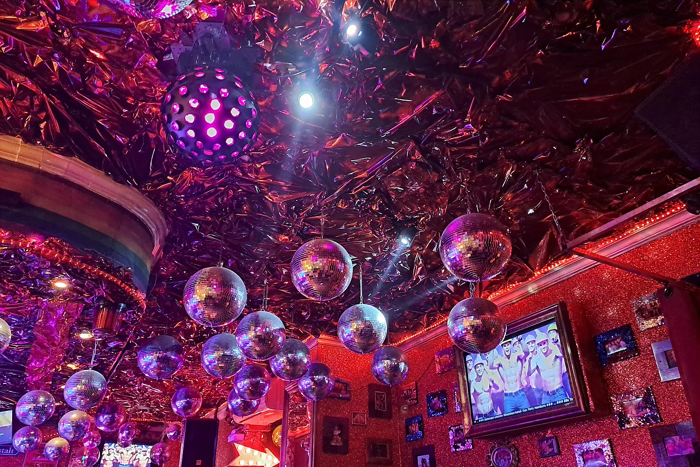 Decke der WunderBar voller Discokugeln über glitzernden Wänden mit gerahmten Bildern