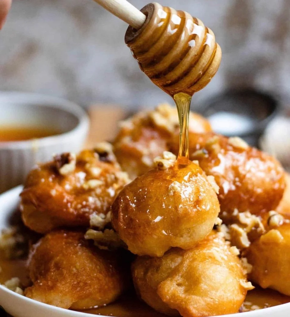 Loukoumades, frittierte Teigbällchen, werden mit Honig übergossen