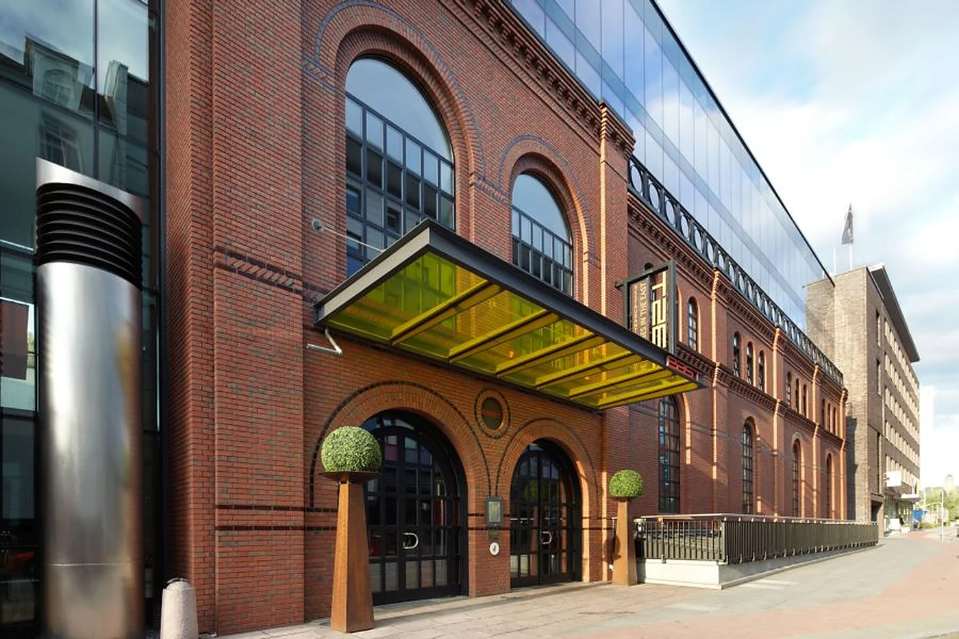 Backsteinfassade des east Hotels in der Simon-von-Utrecht-Straße mit grünem Vordach