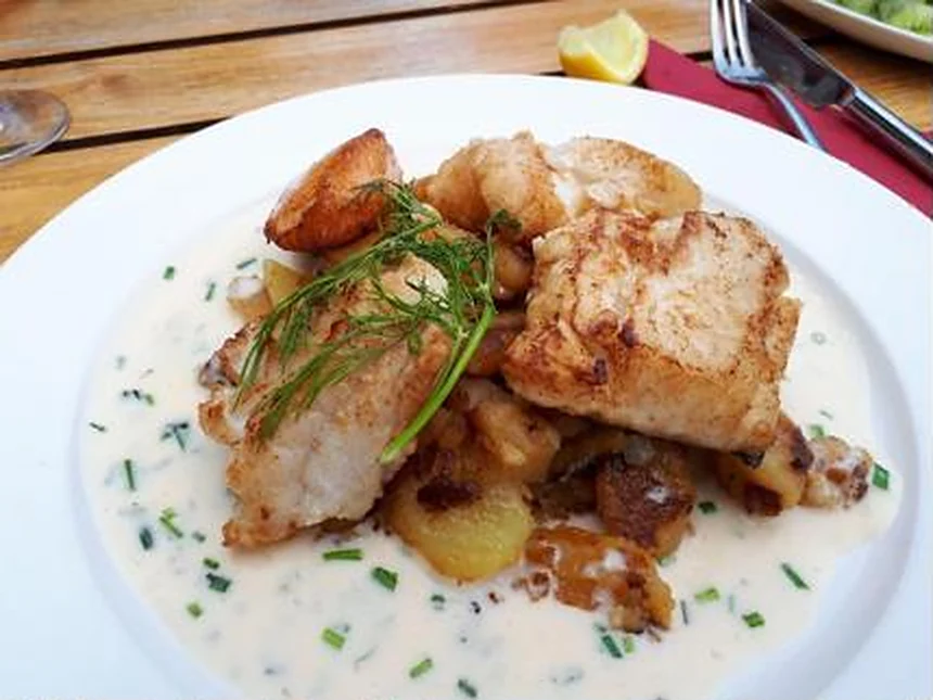 Gebratener Fisch mit Bratkartoffeln in Senf-Sahne-Sauce und Schnittlauch