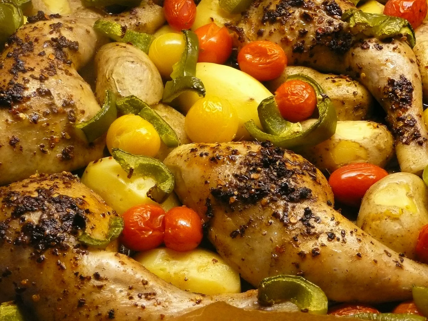 Gebratene Hähnchenschlegel mit Kartoffeln, Paprika und Tomaten aus dem Ofen